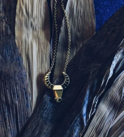 Golden Carabao pendant on tropical leaves – honoring the spirit of the Filipino water buffalo with earthy elegance