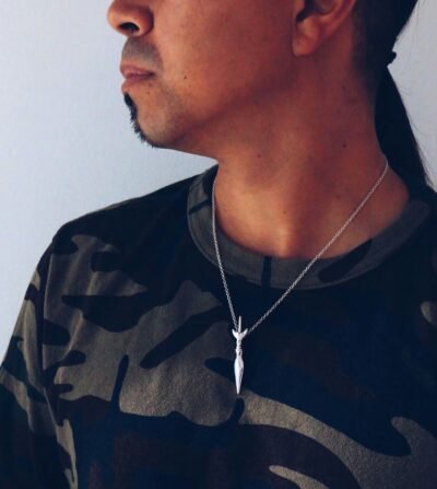 Male model wearing silver Mandaya sword necklace — tribal-inspired warrior pendant rooted in ancestral strength.