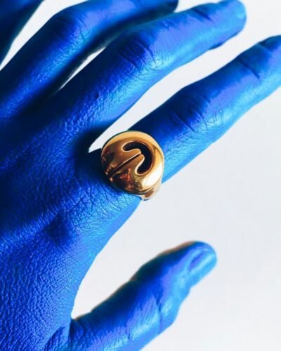 Handcrafted gold Lingling-o ring worn on hand — elegant amulet symbolizing prosperity and the Divine Feminine