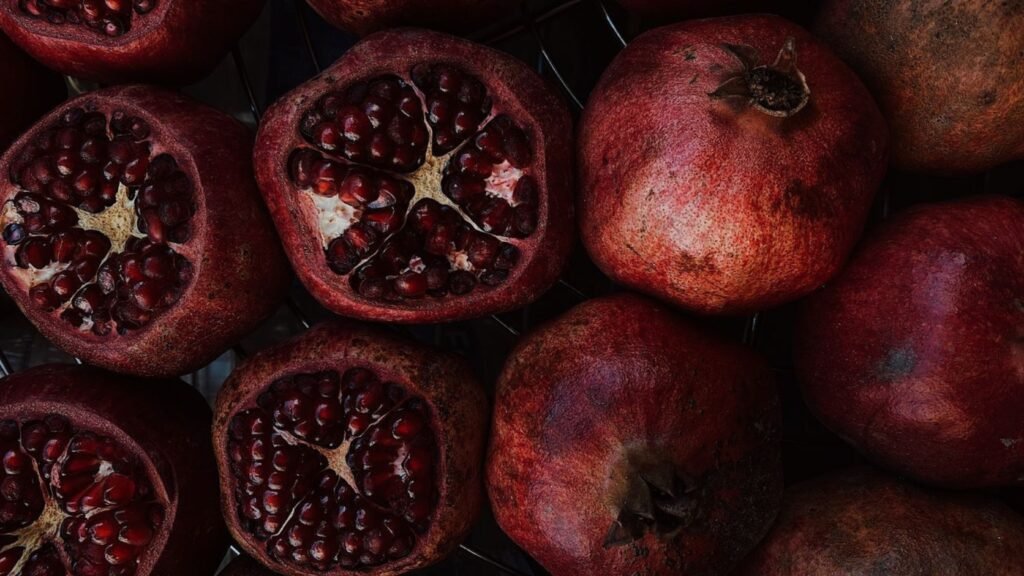 Multiple silver Lingling-o rings displayed on ripe pomegranates — symbols of fertility and abundance meet sacred ancient design