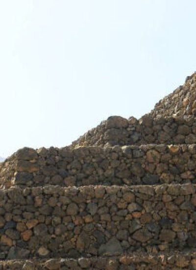Guanche pyramids in Tenerife, Canary Islands, showcasing ancient stone structures against a backdrop of lush foliage and clear sky